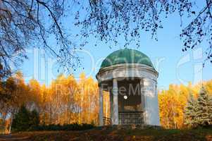 Pavilion in a park with yellow birch trees and blue sky on backg