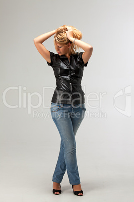 blonde Frau in einem Lederweste und Jeans