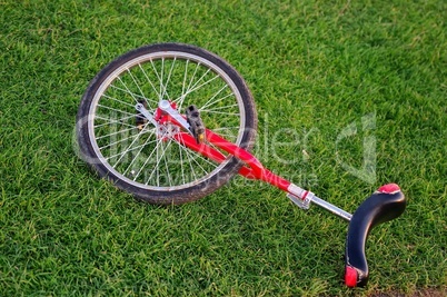 Sport Einrad in Rot liegt auf dem Rasen