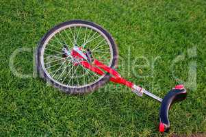 Sport Einrad in Rot liegt auf dem Rasen