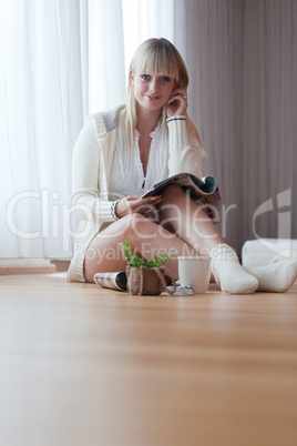 young blond woman sits on the floor