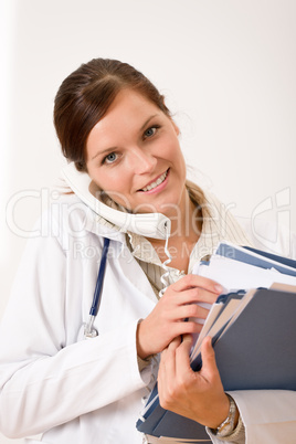 Female doctor on the phone with medical file