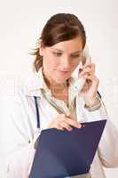 Female doctor on the phone with medical file