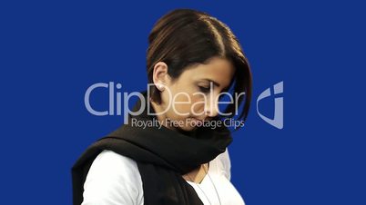 Young woman putting on hat, blue screen background