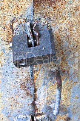 Detail of closed rusty door with padlock