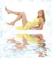 laying girl in yellow dress on white sand