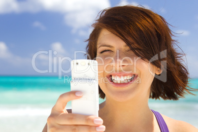 happy woman with phone on the beach