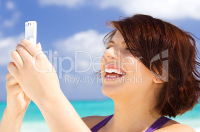 happy woman with phone on the beach