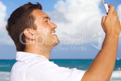 happy man with phone on the beach