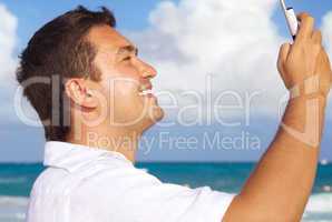 happy man with phone on the beach