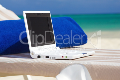 laptop and towel on the beach chaise longue