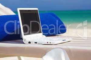 laptop and towel on the beach chaise longue