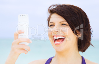 happy woman with phone on the beach