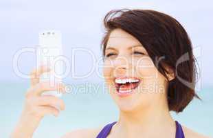 happy woman with phone on the beach
