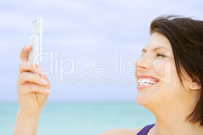 happy woman with phone on the beach