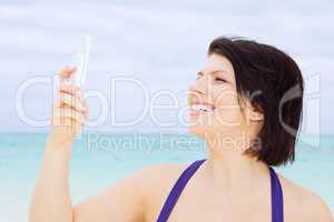 happy woman with phone on the beach