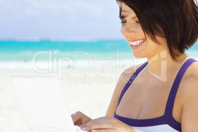 woman with laptop computer on the beach