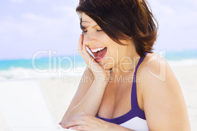 woman with laptop computer on the beach