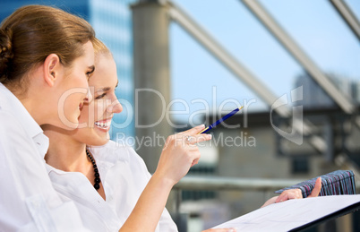 two happy businesswomen with paper chart