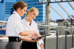 two businesswomen with paper chart
