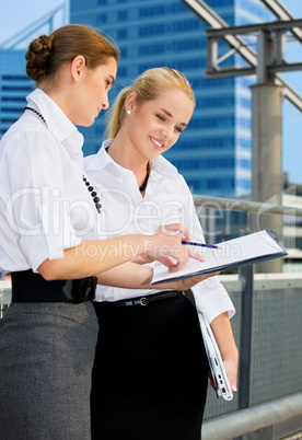 two happy businesswomen with paper chart