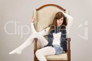 Fashion model posing on antique armchair