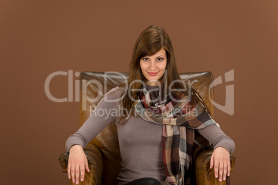 Fashion model on brown leather armchair