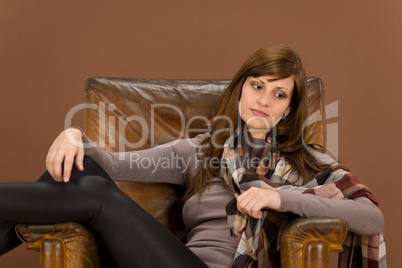 Hispanic woman on brown leather armchair