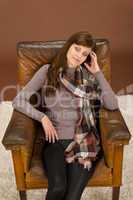 Hispanic woman on brown leather armchair