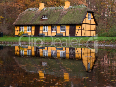 yellow half timbered house at lake