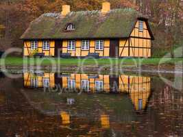 yellow half timbered house at lake