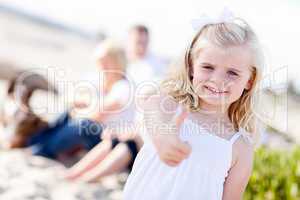 Adorable Little Blonde Girl with Thumbs Up At the Beach