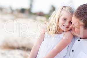 Cute Daughter Cuddles up with Her at the Beach