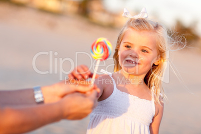 Adorable Little Girl Picking out Lollipop Outside