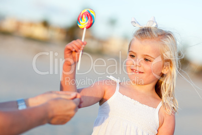 Adorable Little Girl Picking out Lollipop Outside