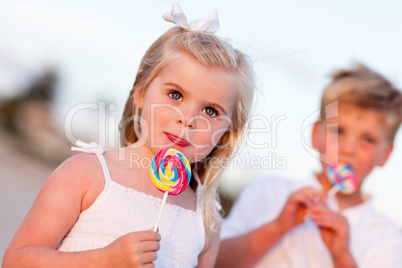 Cute Little Girl and Brother Enjoying Their Lollipops