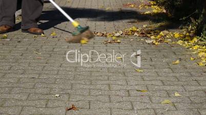 Male Autumn Sweeping Street with Broom