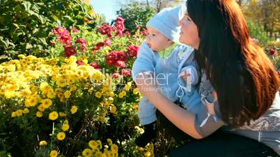 mother and child near a flowerbed
