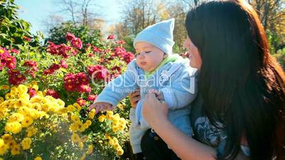 mother and baby near a flowerbed