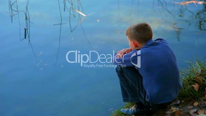 boy sitting by the lake