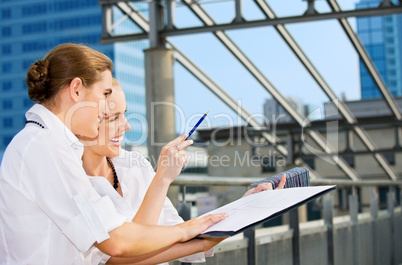 two happy businesswomen with paper chart