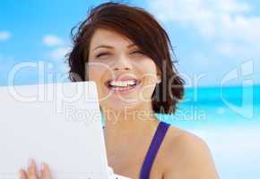 woman with laptop computer on the beach