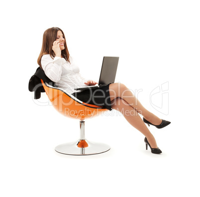 businesswoman in chair with laptop and phone