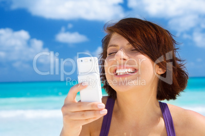 happy woman with phone on the beach