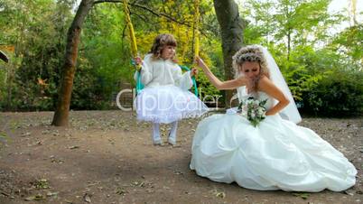 bride with small angel on a swing