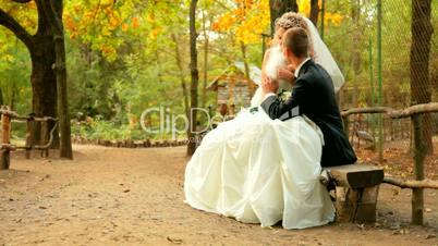 bride and groom on a park bench