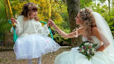 bride with a little girl on a swing