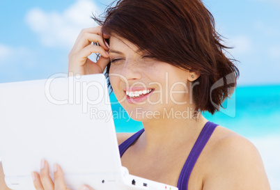 lovely woman with laptop computer on the beach