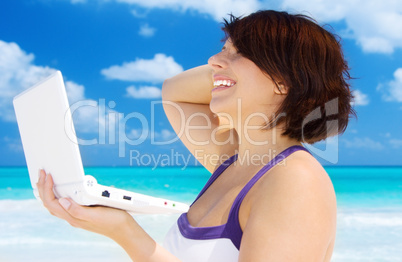 woman with laptop computer on the beach