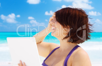 woman with laptop computer on the beach